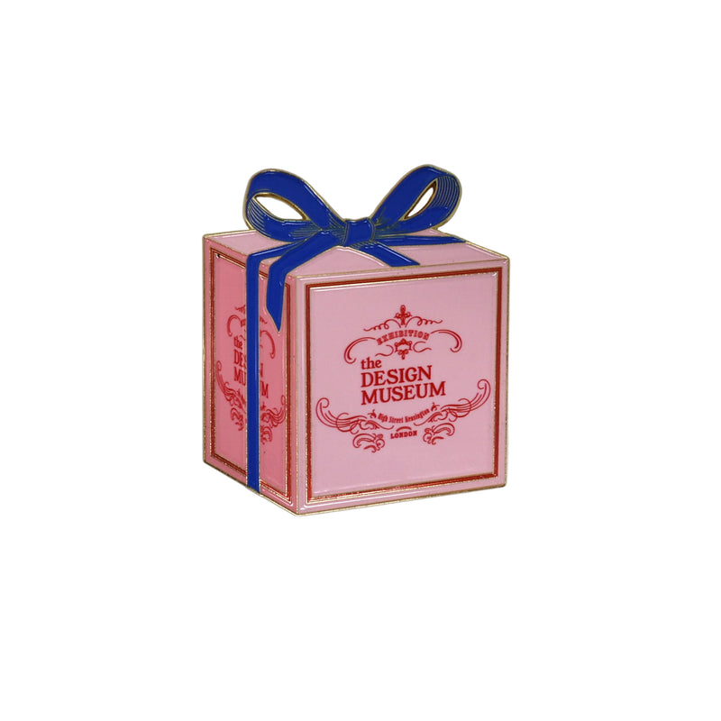 Magnet in the shape of a pink box with blue ribbon and 'The Design Museum' logo on a white background