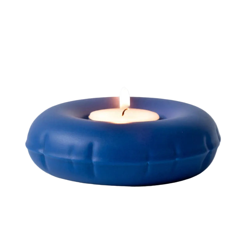 Blue inflatable ceramic candle holder with a lit candle on a white background