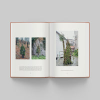 Open book showing images of trees and a building on a gray background