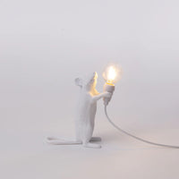 White mouse-shaped lamp holding a light bulb on a grey background