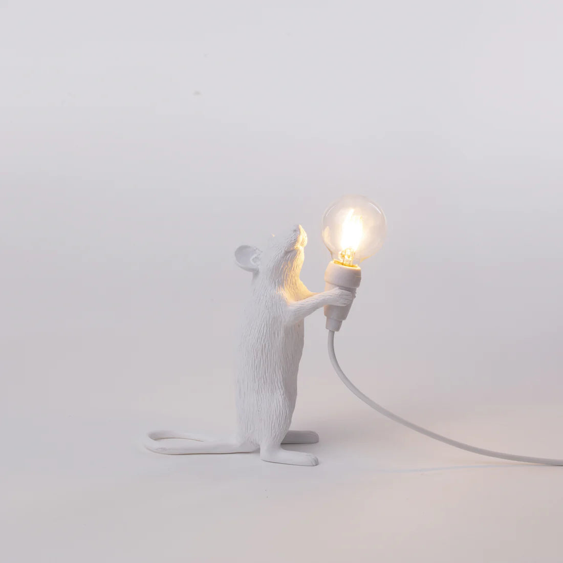 White mouse-shaped lamp holding a light bulb on a grey background