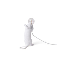 White mouse-shaped lamp holding a light bulb on a white background