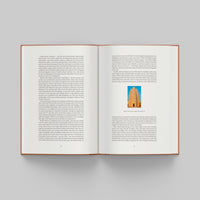Open page of More Than Human catalogue featuring text and a small image of a tower on a gray background