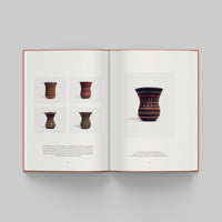 Open page of More Than Human catalogue featuring images of ceramic vases on a gray background