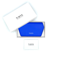A bright blue glasses case by NAOA, presented in a white box next to its white branded outer packaging and a small white card on a white background.