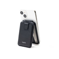 Black wallet phone stand with a white smartphone on a white background