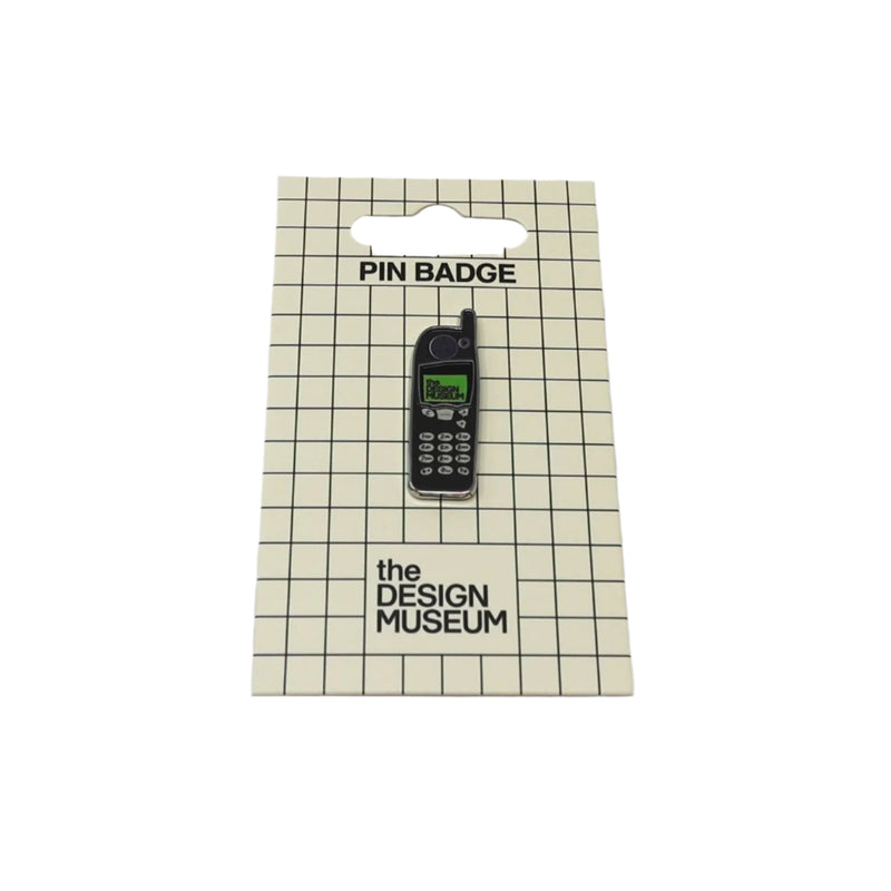 Pin badge of a vintage phone on packaging from The Design Museum
