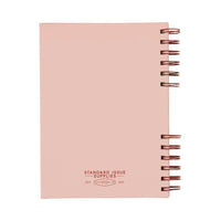 The back of a pink notebook with reed spiral binding on a white background