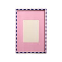 Pink picture frame with blue polka dot border on a light gray background