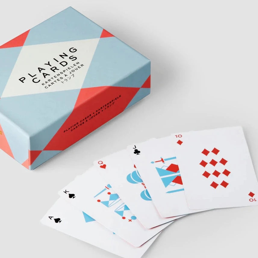 Blue and red playing cards spread out on a white table next to a blue and red box.