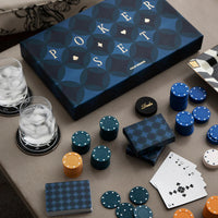 Navy blue poker set with chips, cards, and dice on a table next to a blue box labeled.