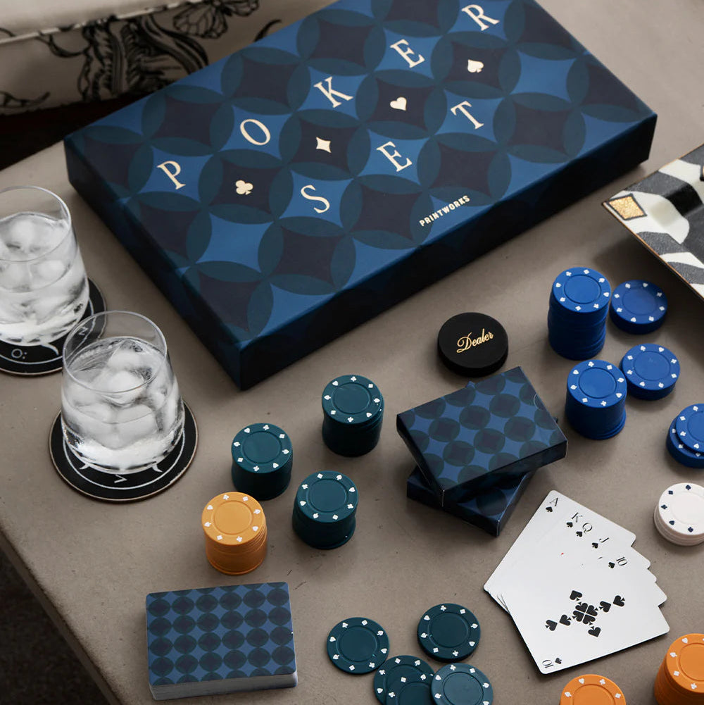 Navy blue poker set with chips, cards, and dice on a table next to a blue box labeled.