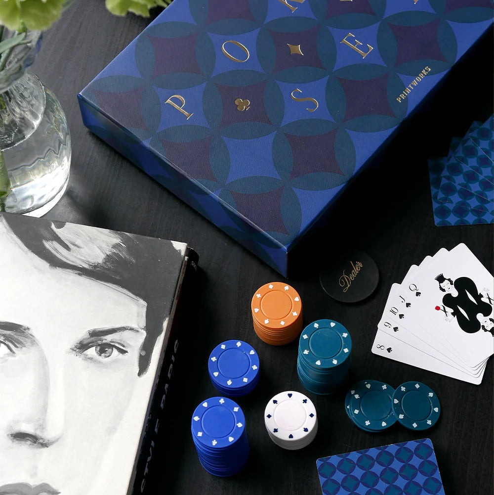 Poker set with chips, cards, and a blue patterned box on a dark surface.