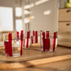 Conran Shop real Christal thin transparent tumbler glass cup with some hand painted burgundy stripes with water on it, lifestyle photo on wood tray, indoors sunny day, all 4 cups together