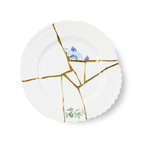 White porcelain plate with gold kintsugi design and floral patterns on a white background