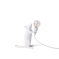 White mouse-shaped lamp holding a light bulb on a white background