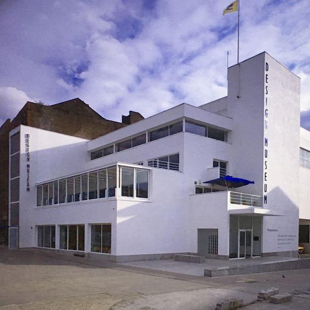 White modern building with 'Design Museum' sign against a blue sky with clouds