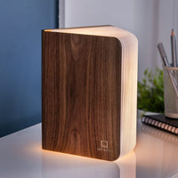 Wooden book-shaped lamp on a surface with a blurred background