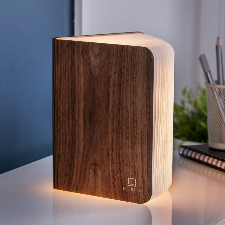 Wooden book-shaped lamp on a surface with a blurred background