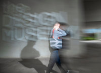 Person walking past the Design Museum with a bag, blurred motion effect