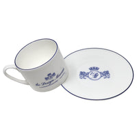 White mug and saucer set with blue design on a white background