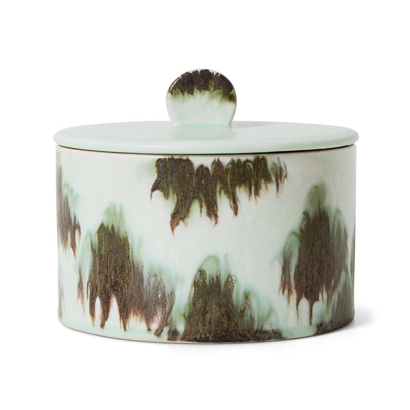 A green and black abstract ceramic storage jar on a white background