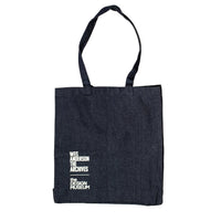 Black tote bag with white text on a beige background