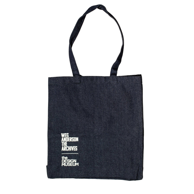 Black tote bag with white text on a beige background