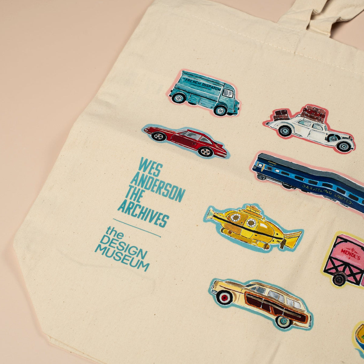 Beige tote bag with colorful vehicle illustrations and text on a beige background
