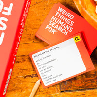 A set of orange game cards featuring a search bar and different search suggestions on a wooden table.