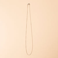 Silver necklace chain on a beige background