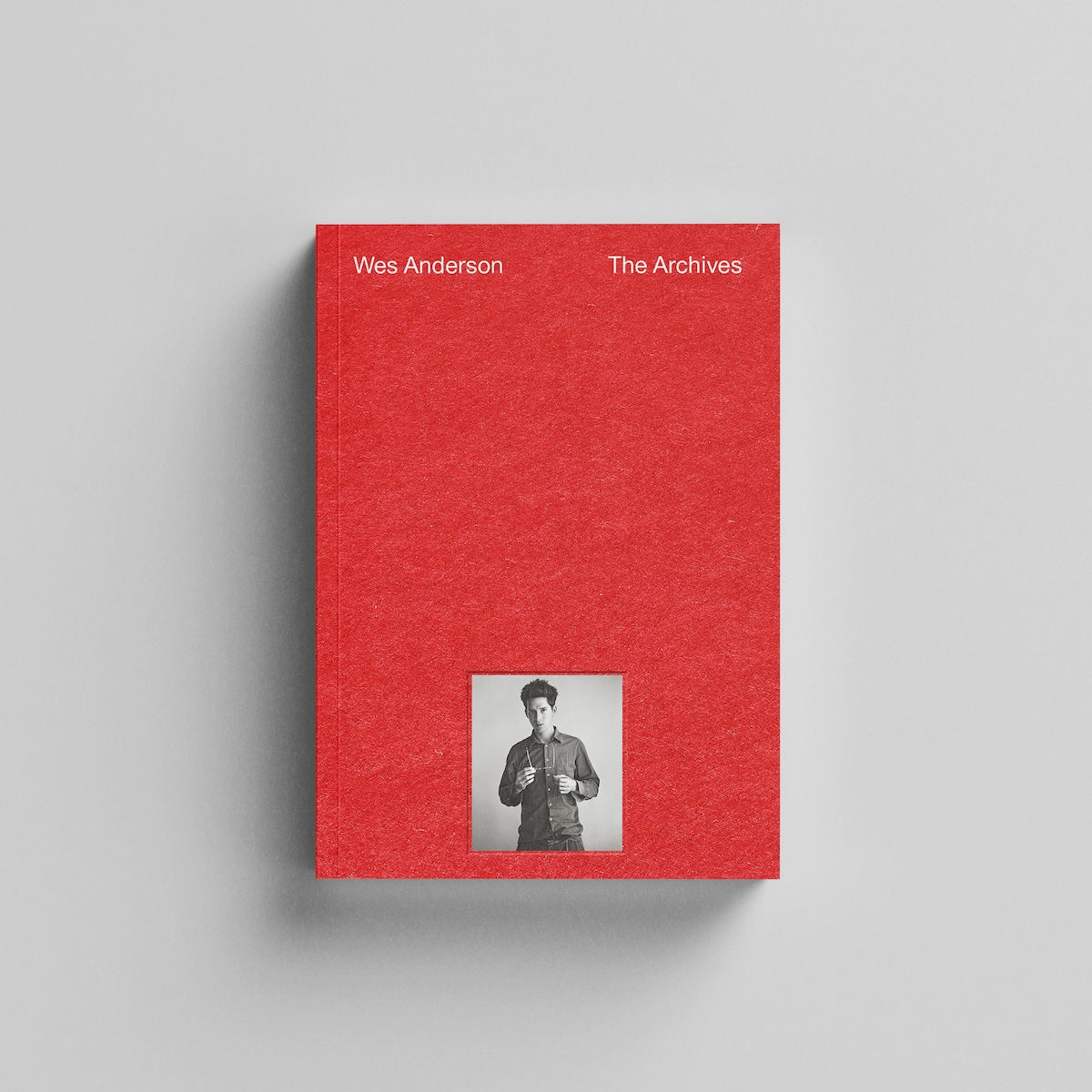 Red book titled 'Wes Anderson The Archives' with a small photo of a person on a gray background