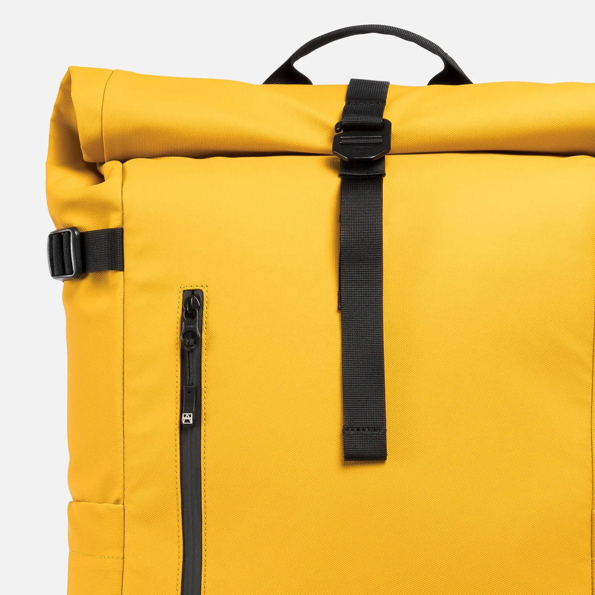 Close-up of a yellow rolltop backpack with black straps, buckles, and a vertical zippered pocket on a light gray background.