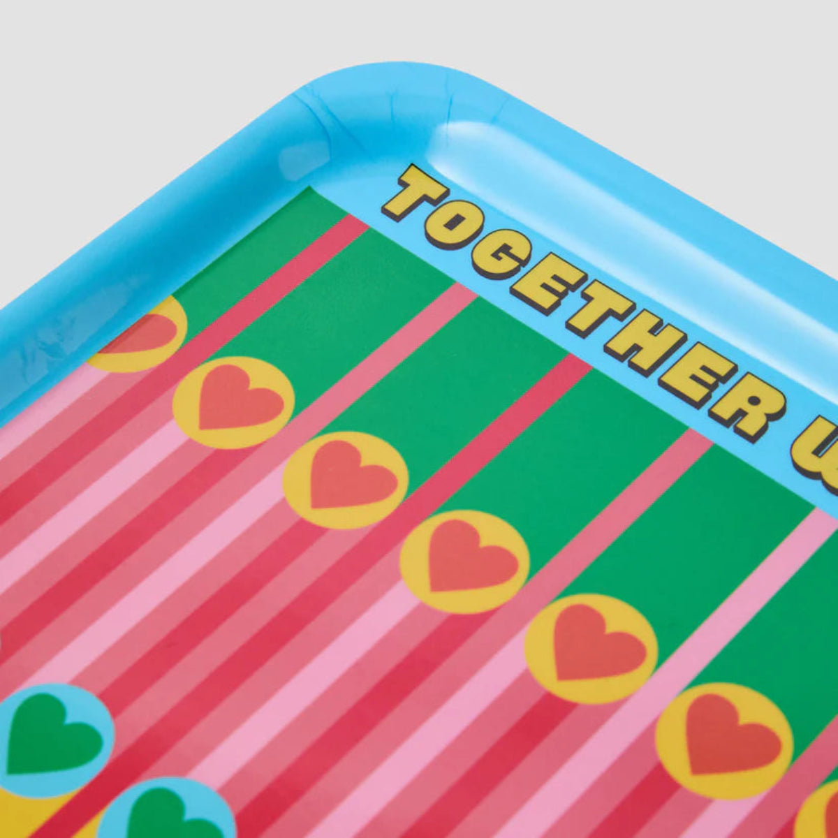Colourful tray with heart designs and  text on a light gray background