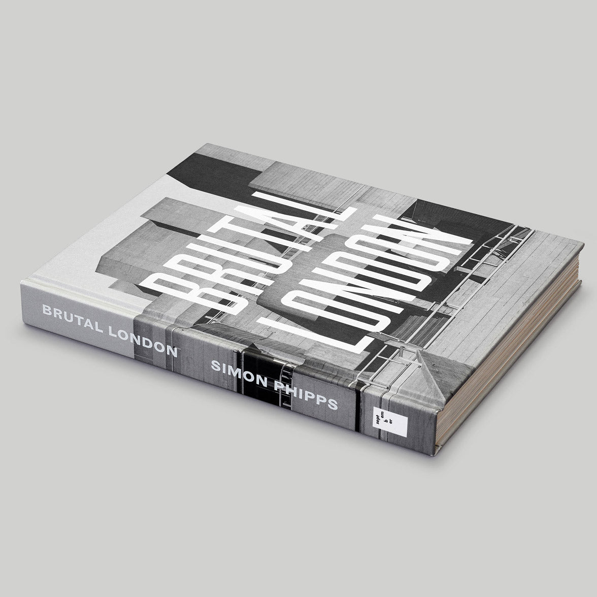 Grey book with white text with spine visible on a grey background