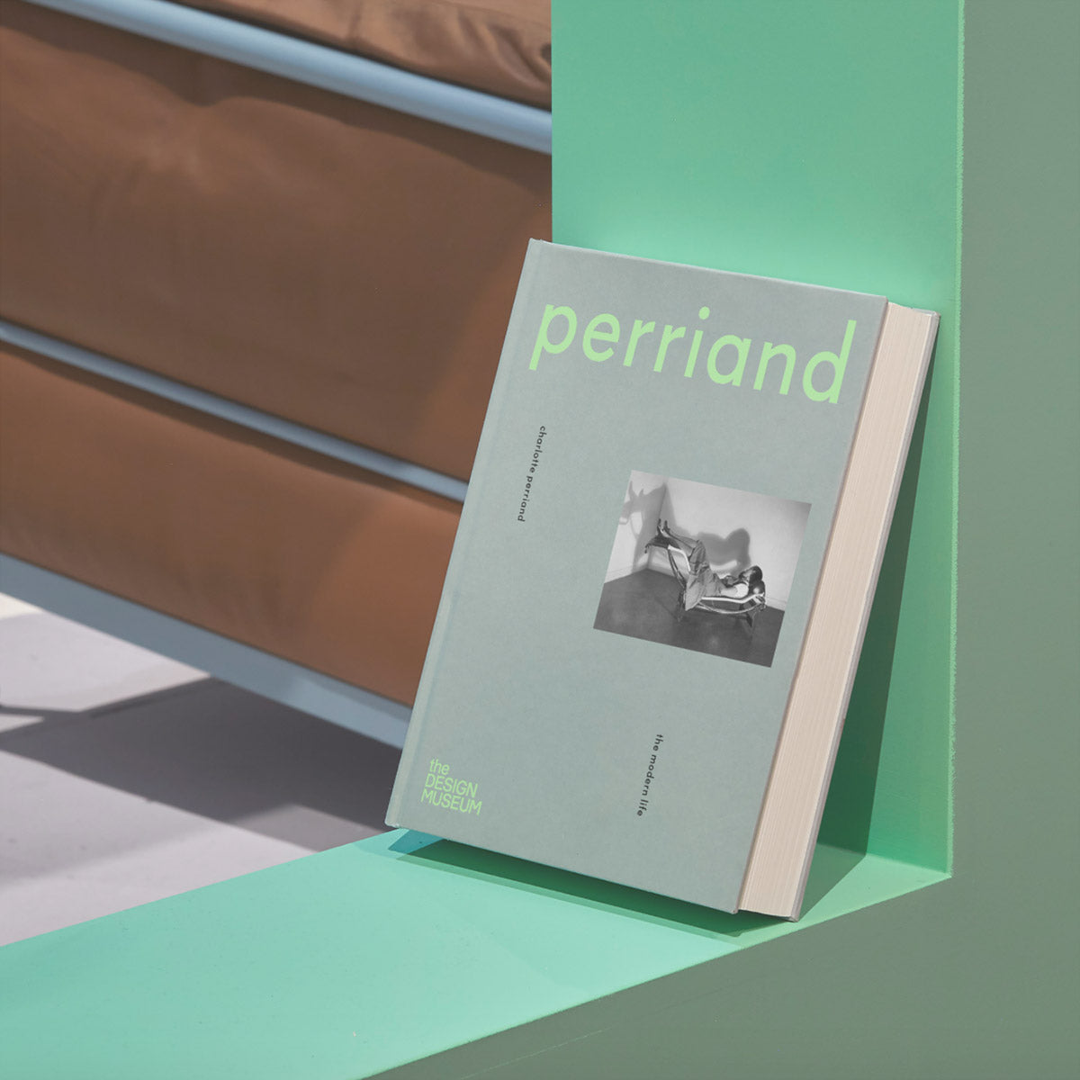 Front cover of Charlotte Perriand catalogue against a green L-shaped bend.