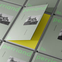 Several copies of sage green Charlotte Perriand catalogues with one ajar, featuring a yellow inside page.