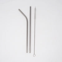 Stainless steel straws and cleaner on a white background