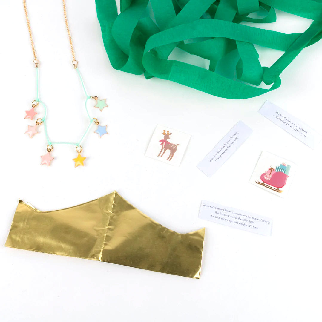 Contents of paper christmas tree feauring unravelled green paper, a golden crown, stickers and a star necklace.