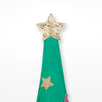 Close up of a sparkly gold star on top of a green paper christmas tree on a white background. 