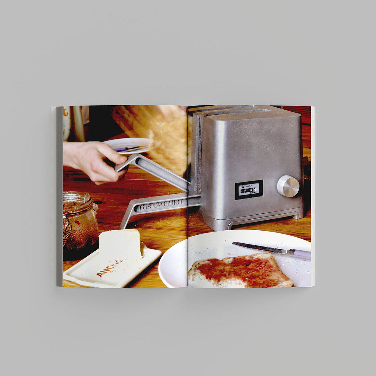 Inside page of Waste Age catalogue featuring a hand pressing a lever on a metal toaster.